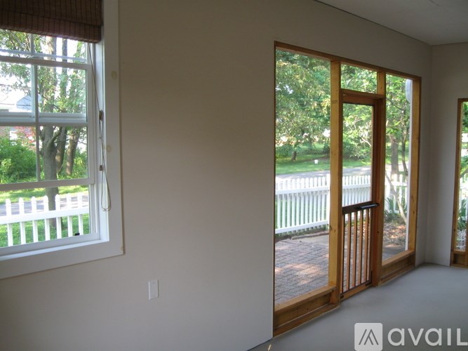 A room with a large window and a door leading to a deck.