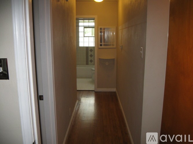 A hallway with a door on the left and a window on the right.