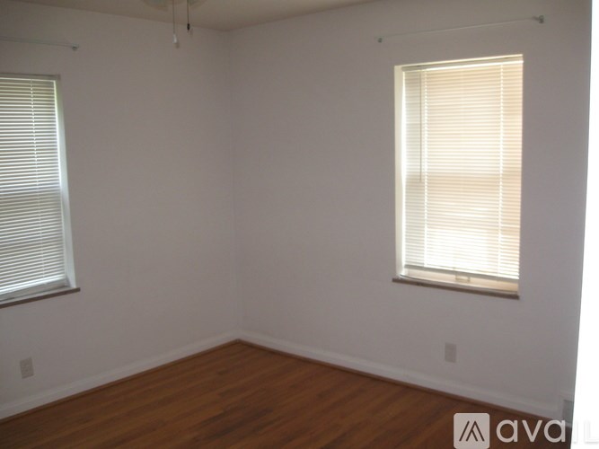 A room with a window and a wooden floor.