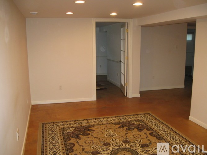 A hallway with a wooden floor and a white door.
