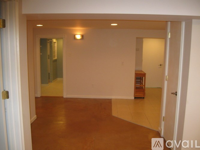 A room with a brown floor and white walls.