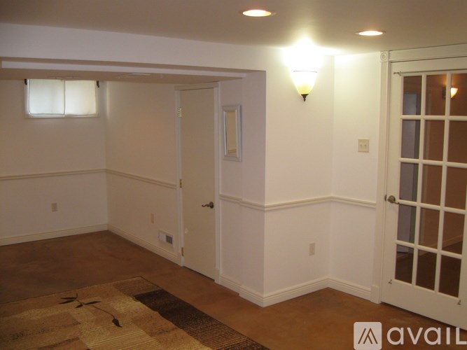 A room with a rug on the floor and a door on the right side.