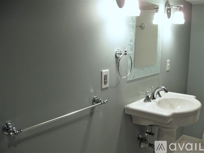 A bathroom with a sink, mirror, and light fixtures.