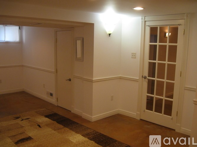 A room with a rug and a door.