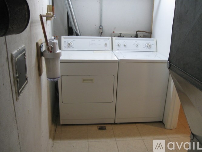 A washing machine and dryer are sitting next to each other in a small room.