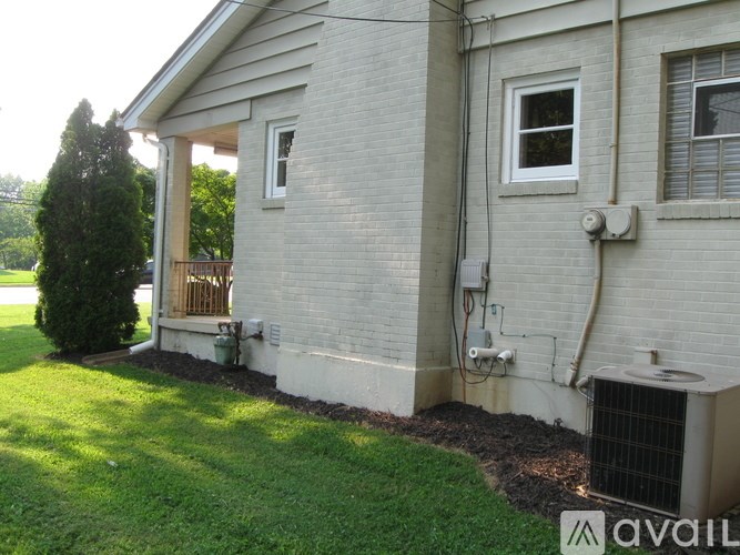 A house with a white brick exterior and a grey roof.