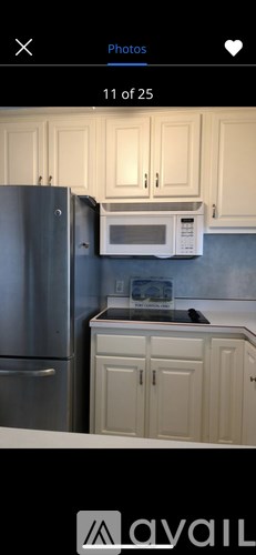 A kitchen with a refrigerator, microwave, and cabinets.