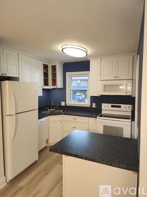 A kitchen with white appliances and cabinets.
