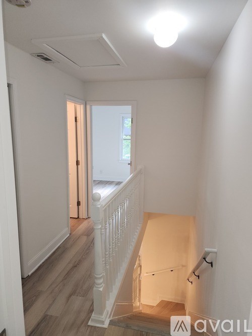 A white interior with a staircase leading to a door.