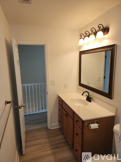 A bathroom with a sink, mirror, and wooden cabinets.