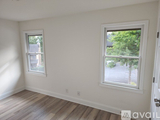 A room with a window and wooden flooring.