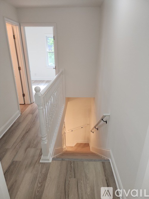 A white staircase with wooden steps and a white railing.