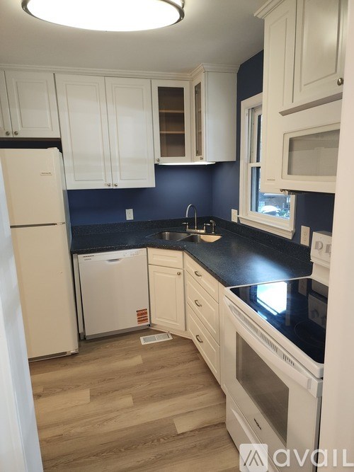 A kitchen with white appliances and cabinets.