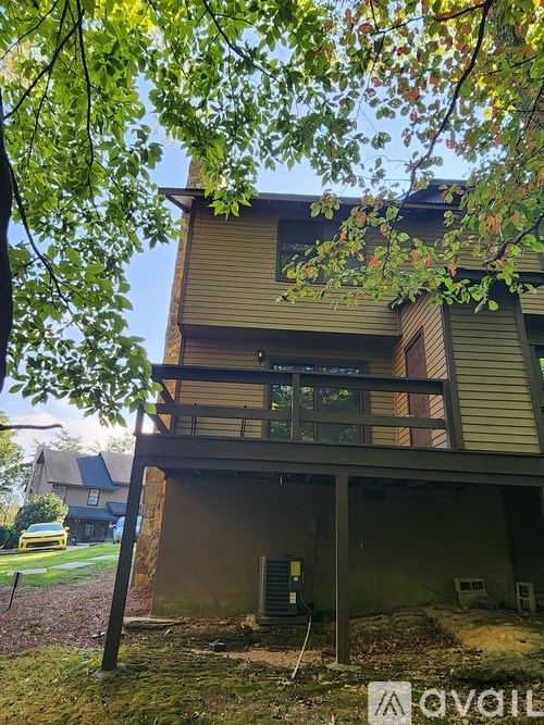 A house with a balcony and a tree in front of it.