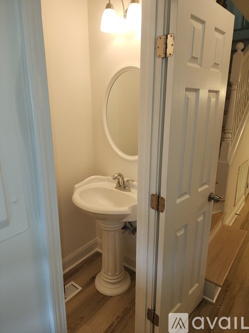 A white pedestal sink in a small bathroom.