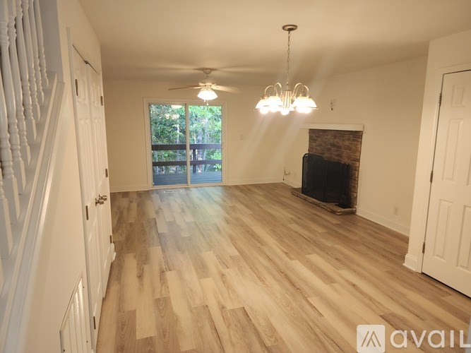 A living room with a fireplace and a chandelier.