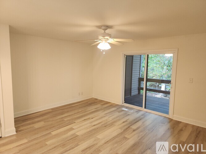 A room with wooden flooring and a ceiling fan.