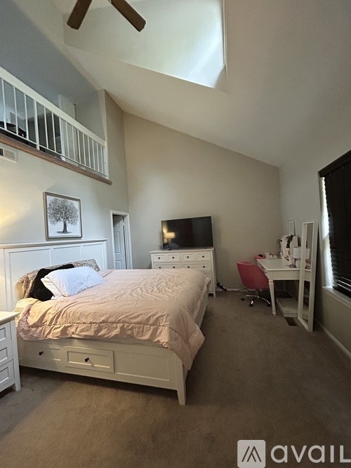 A bedroom with a bed, desk, and chair.