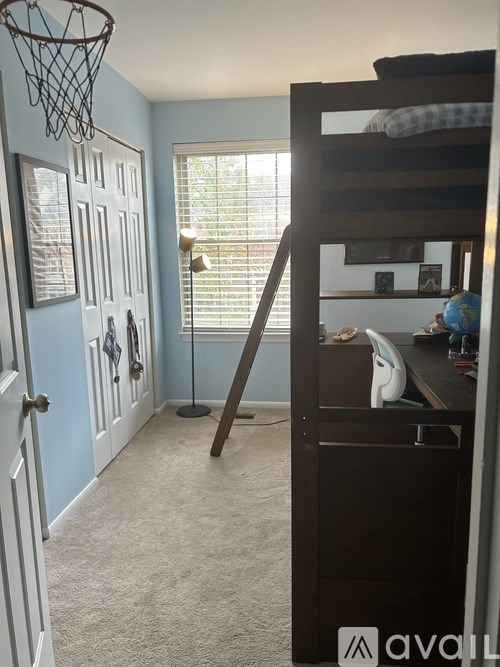 A room with a bunk bed and a basketball hoop.