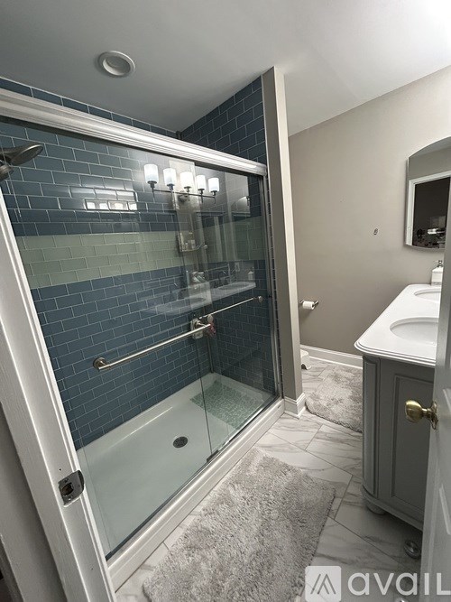 A bathroom with a glass shower door and a white sink.