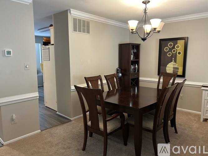 A dining room with a table and chairs.