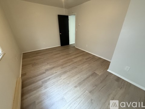 A room with wooden flooring and a black wardrobe.
