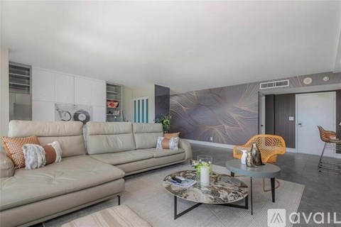 A living room with a grey sofa and a patterned wallpaper.