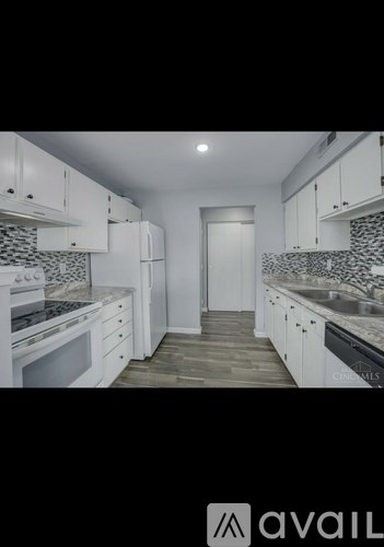 A kitchen with white cabinets and a tile backsplash.
