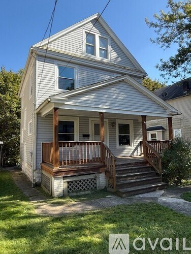 A house with a front porch and stairs leading up to the door.