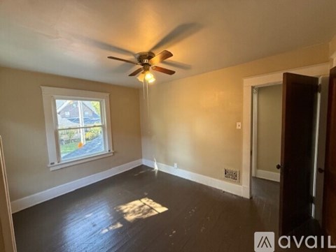 A room with a ceiling fan and a window.