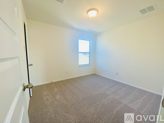 A room with a carpeted floor and a window.