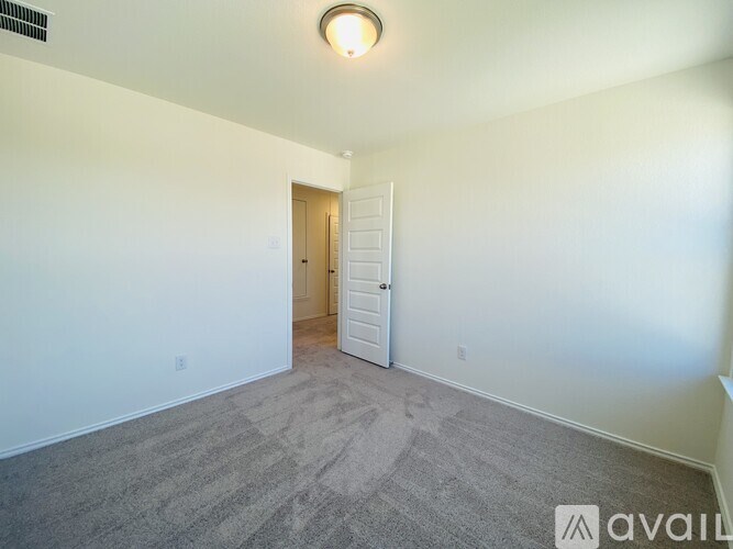 A room with a carpeted floor and a doorway leading to another room.