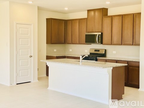 A kitchen with brown cabinets and a white island.