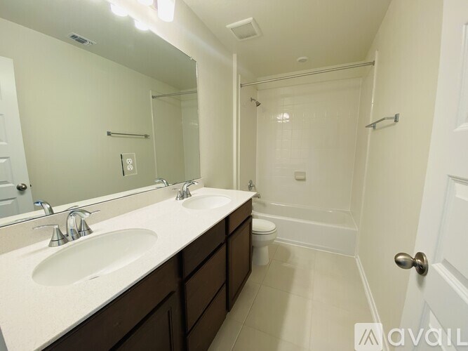 A bathroom with a sink, mirror, toilet, and bathtub.