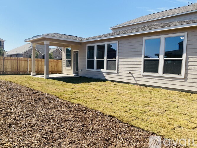 A house with a brown fence and a covered patio.