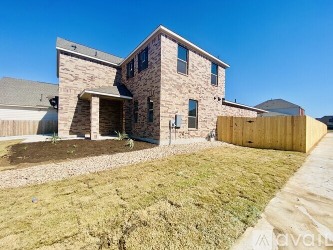 A house with a stone exterior and a wooden fence in front.
