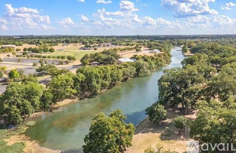 A river flows through a green landscape with trees on both sides.