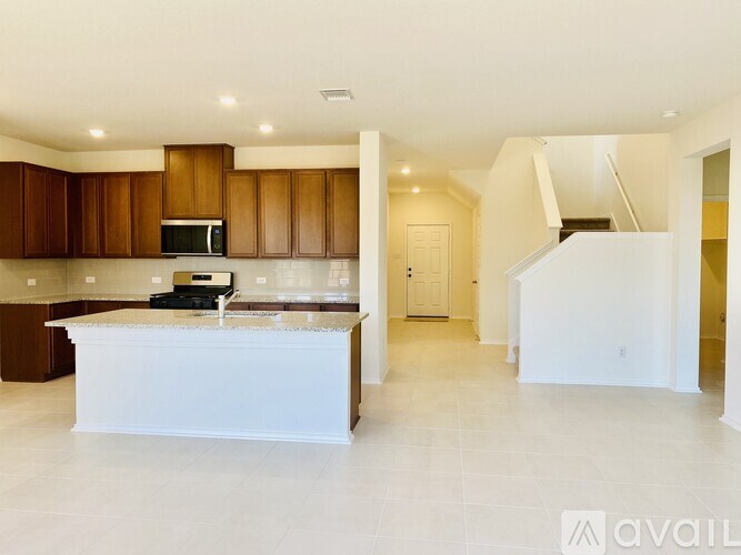A spacious kitchen with brown cabinets and a white island.