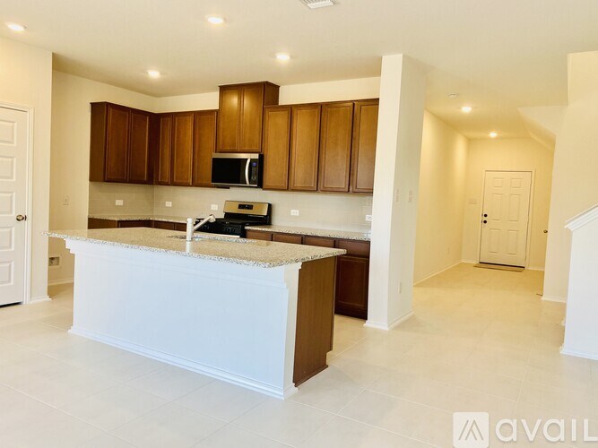 A kitchen with brown cabinets and a white island.