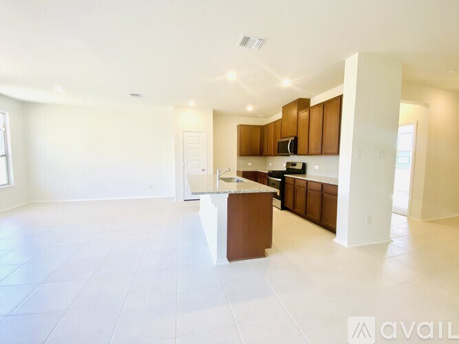 A spacious kitchen with white walls and a central island.