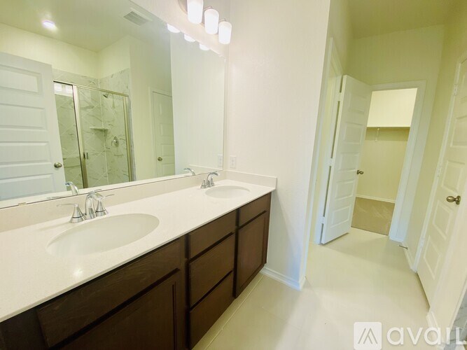 A bathroom with a double sink vanity and a large mirror.