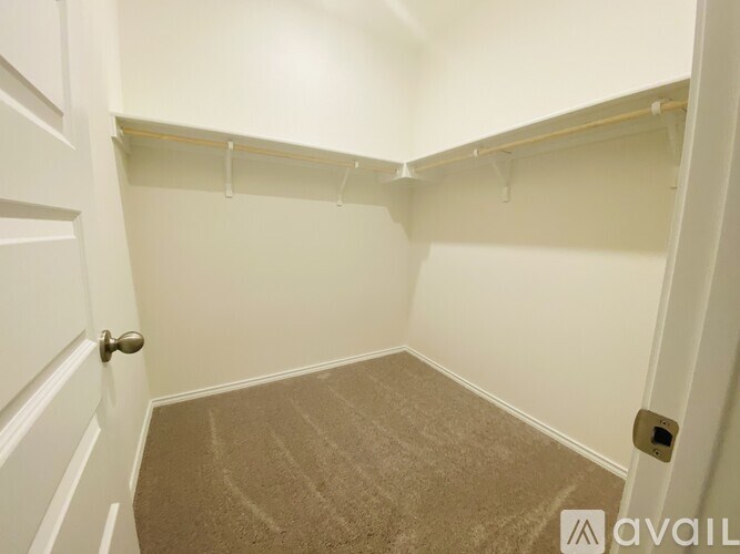 A small, empty room with a carpeted floor and white walls.