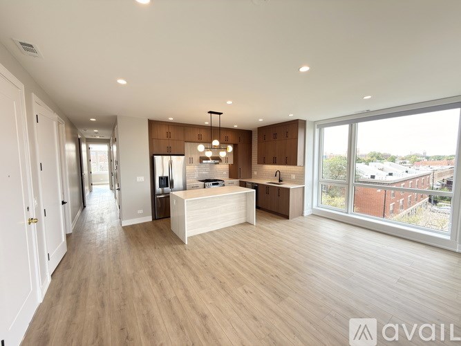 A spacious kitchen with wooden floors and a large island.