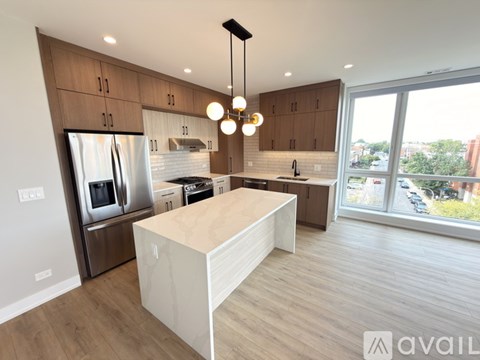 A modern kitchen with wooden cabinets and a large island.