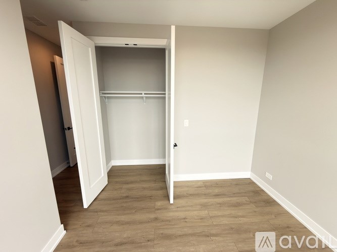 A room with a white door and a wooden floor.