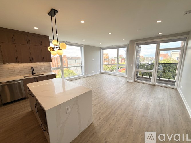 A modern kitchen with wooden floors and a large island.