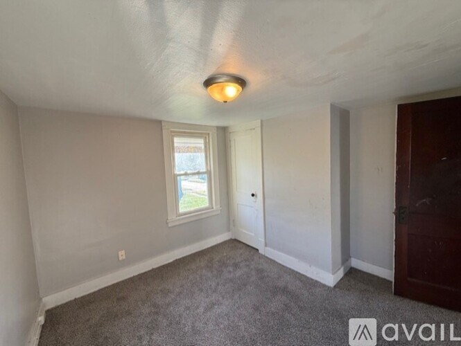 A room with a window and a door is available for rent.