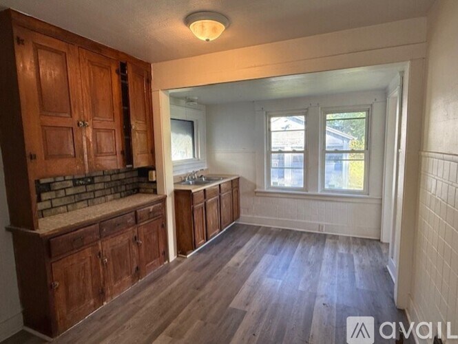A kitchen with wooden cabinets and a brick backsplash.
