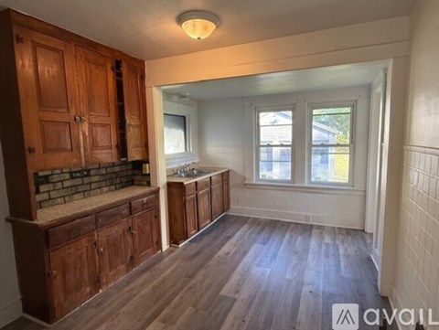 A kitchen with wooden cabinets and a brick backsplash.