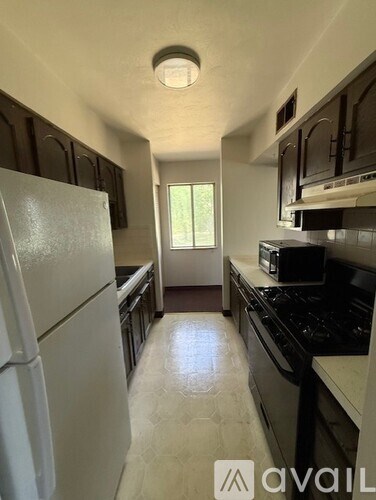 A kitchen with a white refrigerator and black appliances.